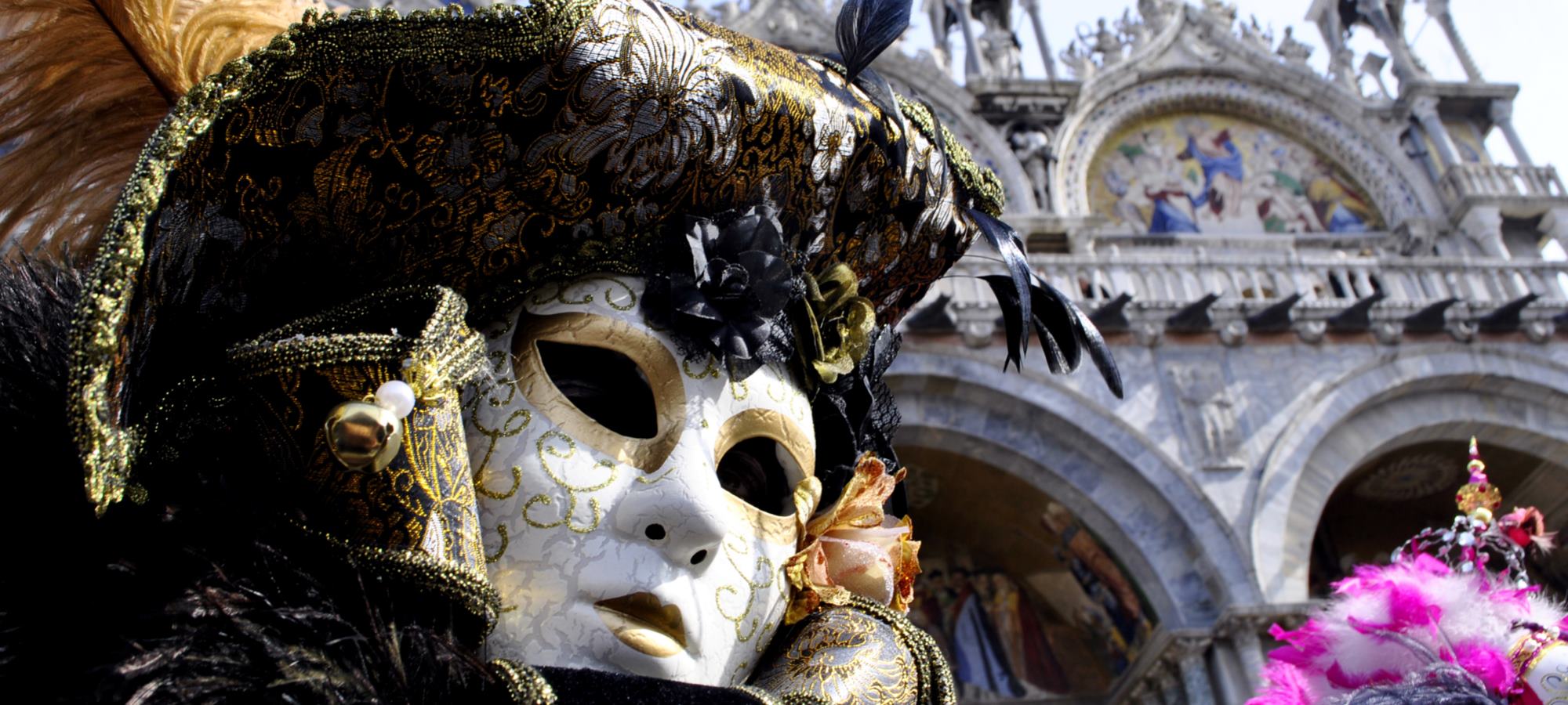 Mascara de carnaval y de fondo un edificio con arquitectura renacentista